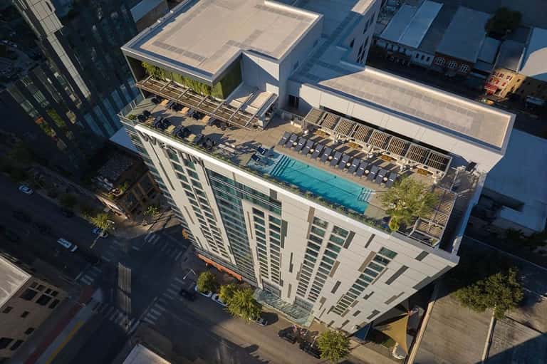 Rooftop pool deck with lounge chairs at modern urban hotel building