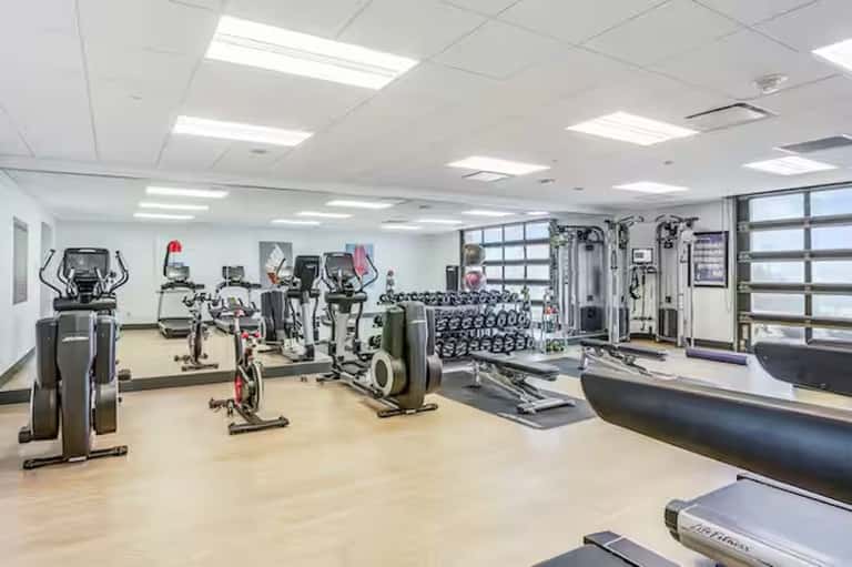 Bright fitness center with cardio equipment, weights, and strength training machines