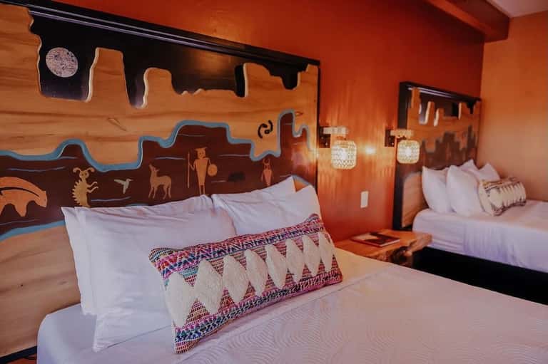 Southwestern-style bedroom with orange walls, Native American art, and patterned pillow