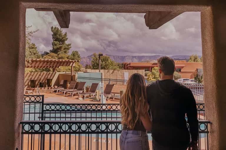 Couple viewing desert landscape and red rock formations from hotel balcony