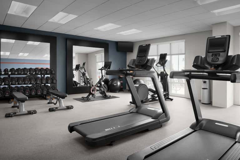Modern hotel fitness center with treadmills, exercise bikes, and strength equipment