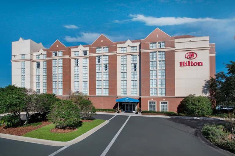 Hilton hotel exterior, red brick building with white trim under blue sky