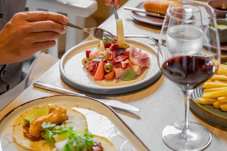 Fine dining table with plated appetizers, wine glasses, and bread service
