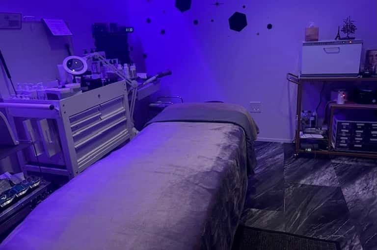 Bedroom with purple ambient lighting, bed, tool cabinet, and computer equipment