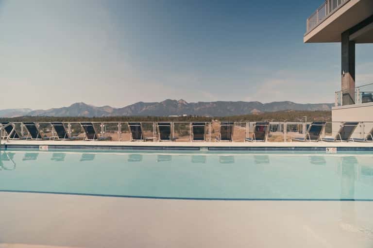 Rectangular resort pool with mountain views and lounge chairs in scenic desert landscape