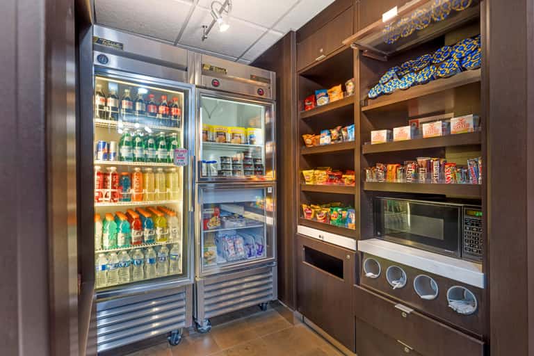 Convenience market with refrigerated beverage display, snack shelves, microwave, and supplies