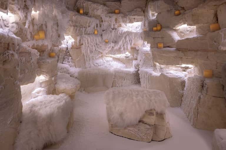 Pamukkale thermal pools with white mineral terraces, seated figures, and golden accent lighting