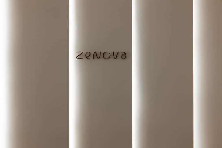 Modern corridor with Zenova signage, illuminated vertical panel walls, and neutral palette