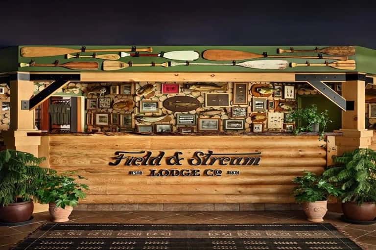 Field & Stream Lodge Co entrance with wooden signage, oars displayed above, and decorative elements