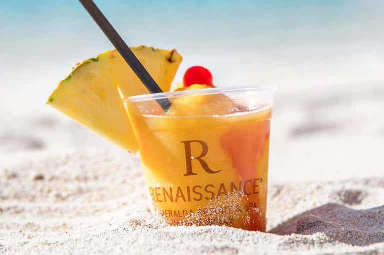 Tropical cocktail with pineapple garnish in sand on a beach