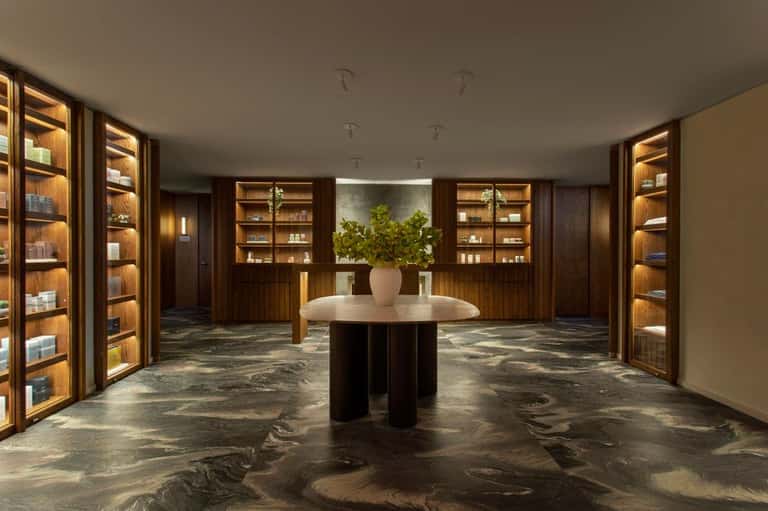 Upscale spa retail space with illuminated wooden shelving and central display table