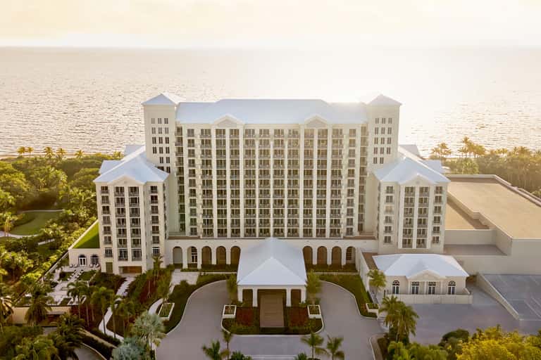 Beachfront resort exterior with cream-colored building and waterfront setting at sunset