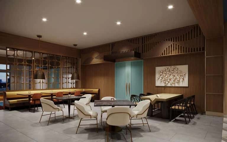 Upscale hotel lounge with wood paneling, cream chairs around marble table, and ambient lighting throughout spacious room