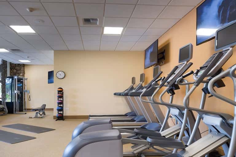Hotel fitness center with treadmills, exercise equipment, and flat-screen TV
