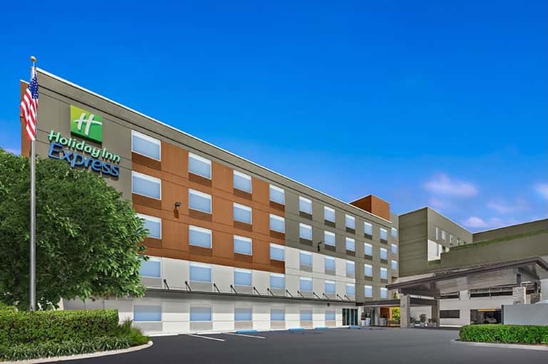 Holiday Inn Express exterior showing multi-story building with orange and tan facade and American flag