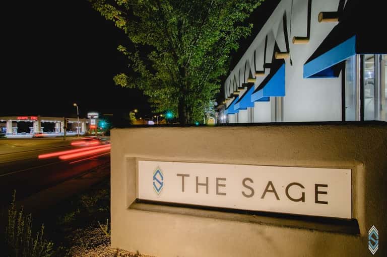 The Sage hotel entrance sign illuminated at night with modern blue architectural detail
