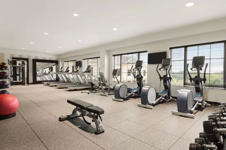 State-of-the-art fitness center with cardio equipment, weights, and floor-to-ceiling windows