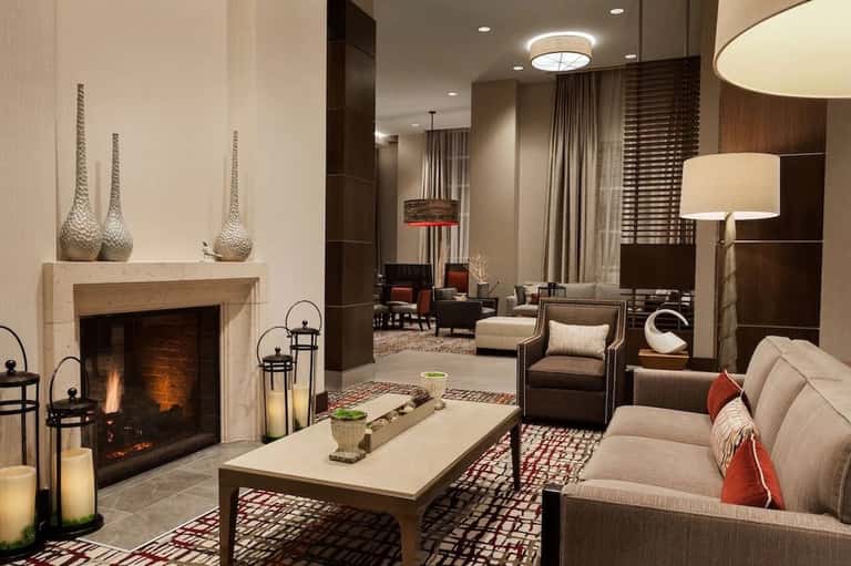 Upscale hotel lobby lounge with fireplace, comfortable seating, and contemporary decor