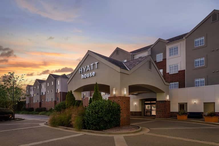 Hyatt House hotel exterior at dusk with brick and stone architecture, residential-style building