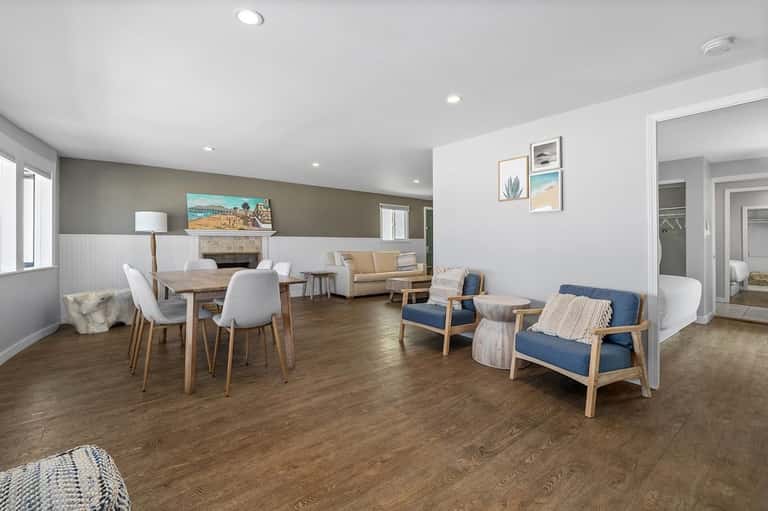 Spacious lounge area with dining table, fireplace, and comfortable seating with blue and beige accents