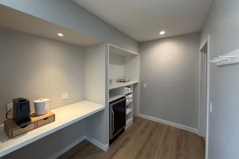 Laundry room with white countertop, built-in shelving, and black dryer