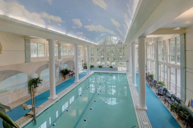 Indoor lap pool with lane markers in a bright, modern facility with extensive windows
