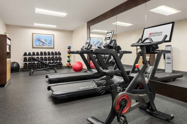 Hotel fitness center with treadmills, exercise bikes, dumbbells, and equipment