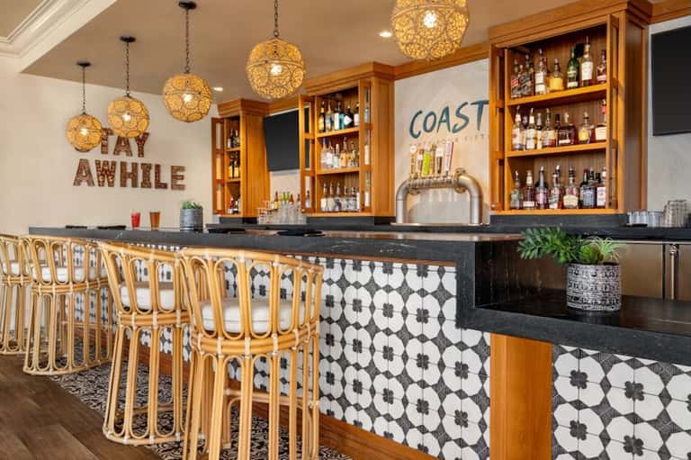 Stylish bar with woven pendant lights, wooden cabinets, and patterned tile accents