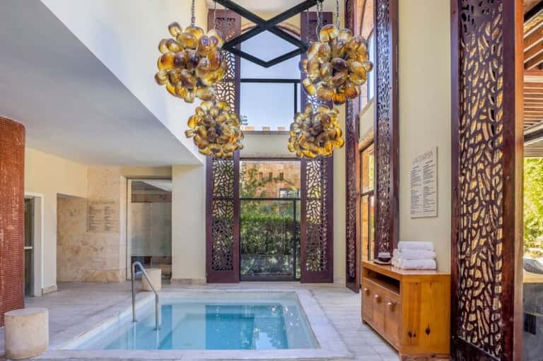 Spa interior with ornate golden chandeliers and decorative carved wooden screens