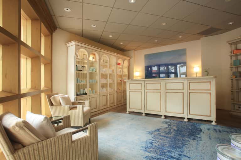 Spa reception area with wooden cabinetry, comfortable seating, and elegant interior design
