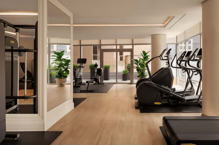 Modern fitness center with cardio equipment, exercise bikes, and strength training machines in a bright, airy space