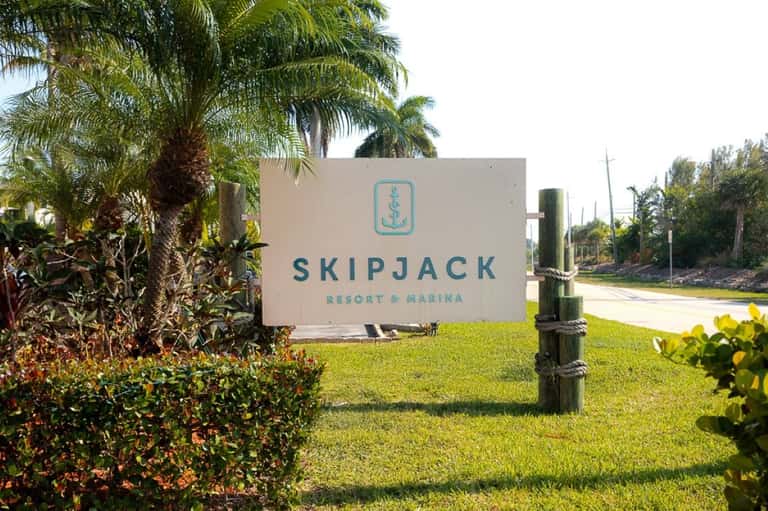 Skipjack Resort & Marina entrance sign with palm trees and waterfront landscape