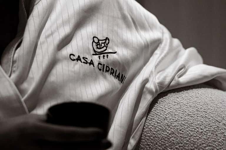 Close-up of white Casa Cipriani spa robe with embroidered logo