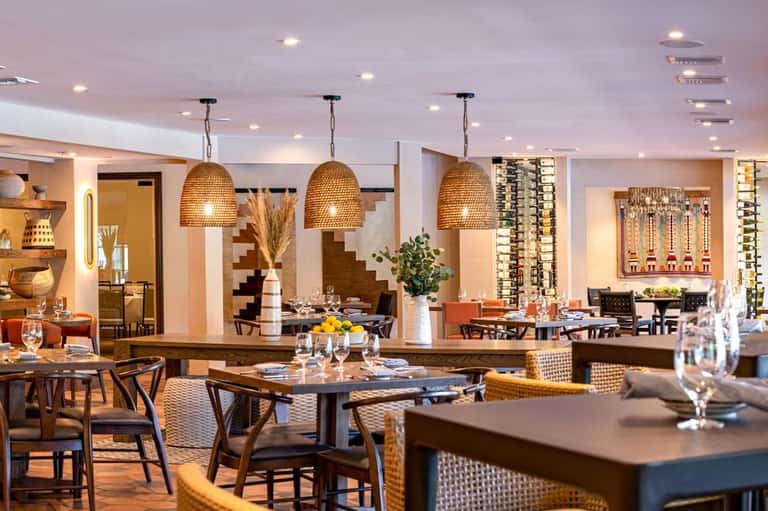 Elegant restaurant dining room with woven pendant lights, wooden tables, and warm ambient lighting