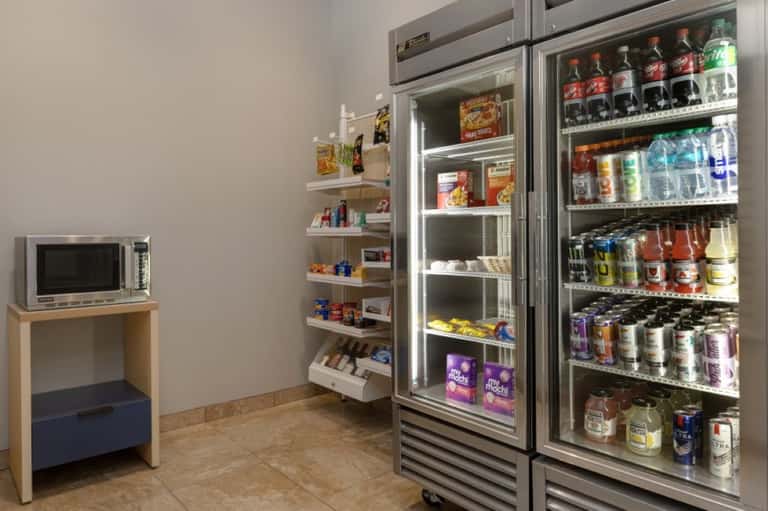 Hotel convenience store with refrigerated beverage coolers and stocked shelving