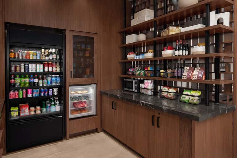 Convenience store with refrigerated displays, vending machines, and wooden shelving
