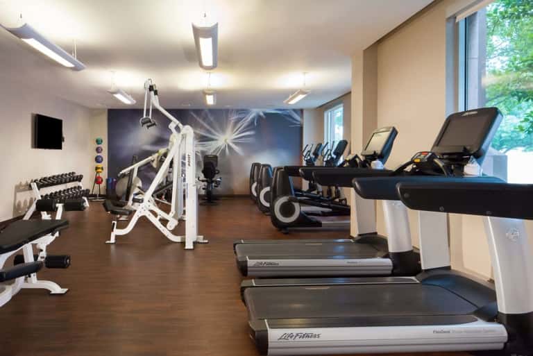 Fitness center with cardio equipment, weights, exercise machines, and large windows