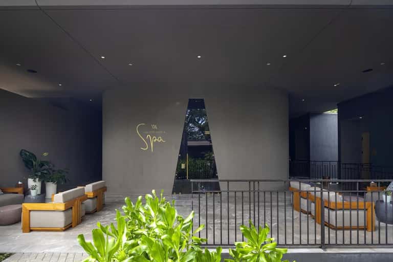 Luxury spa entrance with signage, seating areas, and architectural water feature in contemporary space