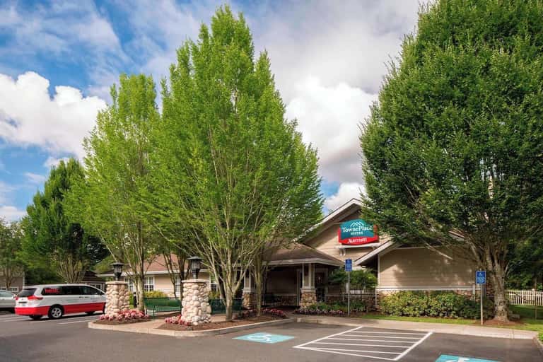TownePlace Suites hotel exterior with tall poplar trees, brick entrance, and professional landscaping