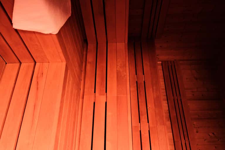 Close-up of red wooden sauna interior showing horizontal wooden bench slats
