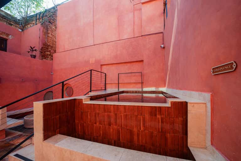 Red spa area with hot tub labeled 'Cold Plunge' and red-tiled walls