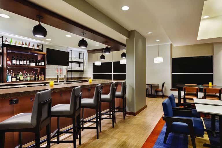 Hotel bar and lounge with wooden accents, leather seating, and large windows