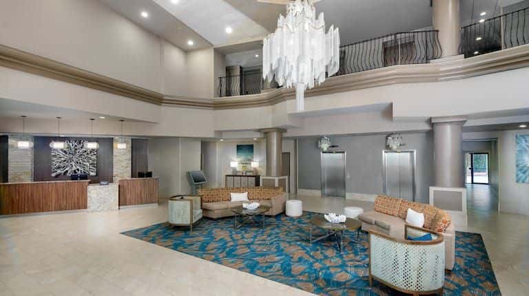 Spacious hotel lobby with high ceilings, chandelier, and contemporary furnishings