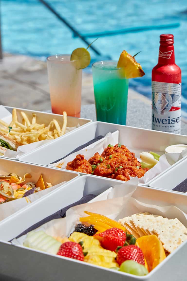 Poolside food and beverages including cocktails, beer, and appetizer platters