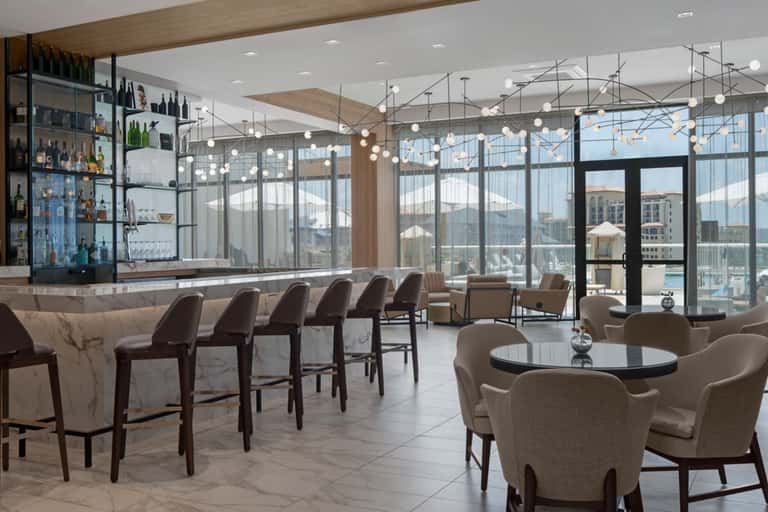 Upscale bar lounge with marble countertop, pendant lighting, and panoramic city views