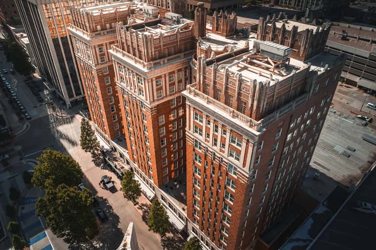 Aerial view of historic red brick building with ornate architectural details and surrounding urban landscape