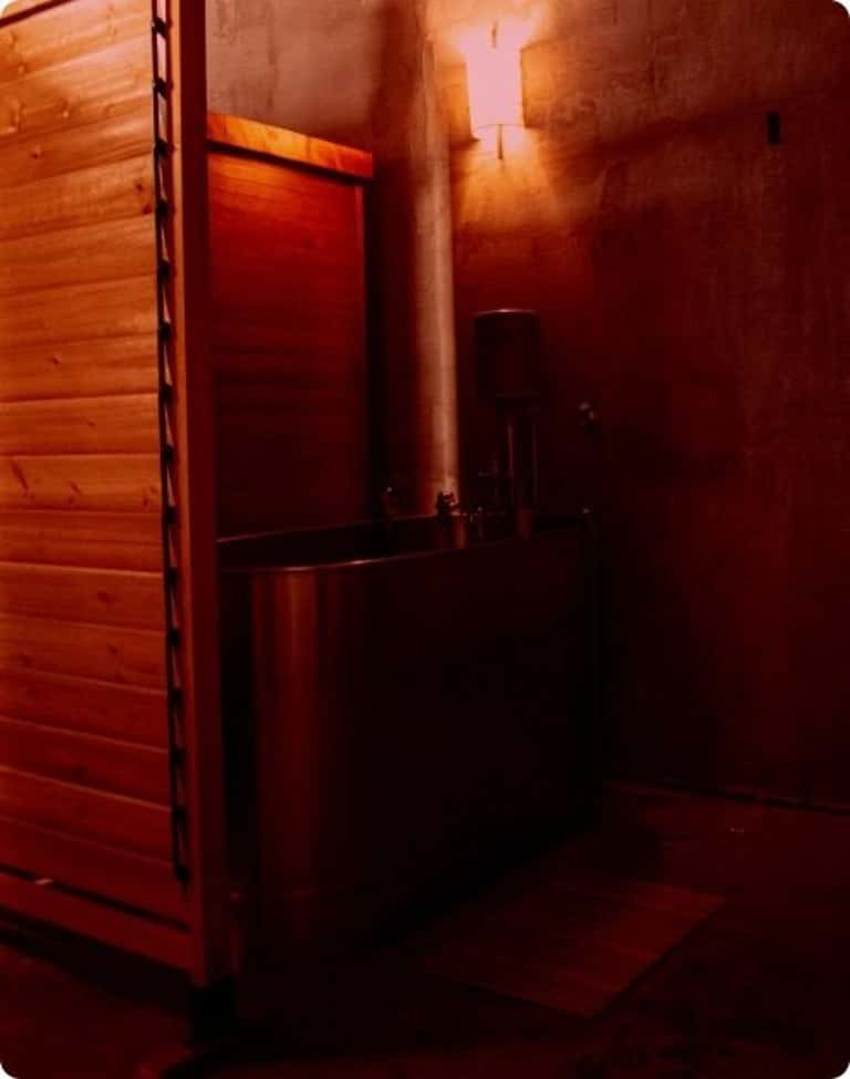 Wooden infrared sauna room with red heat lighting and bench seating