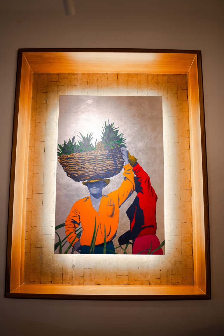 Contemporary framed artwork featuring colorful figure with woven basket headpiece