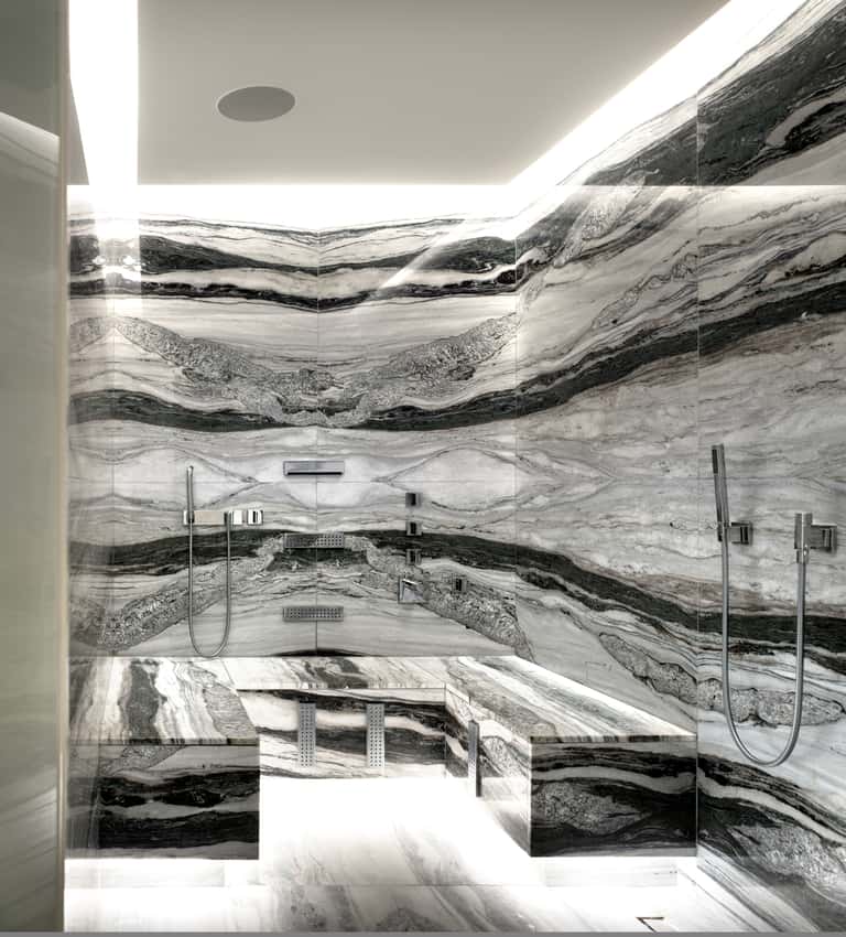 Luxury shower enclosure with dramatic black and white marble striped walls and rainfall showerheads