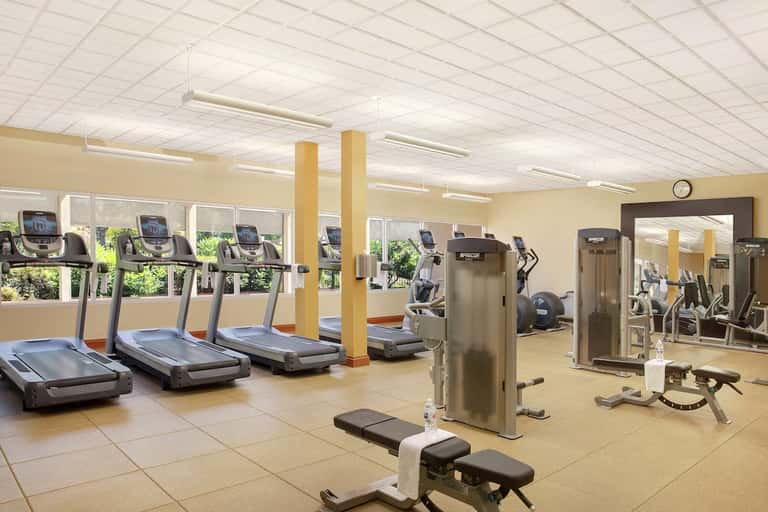 Fitness center with treadmills, exercise equipment, and large windows with natural light
